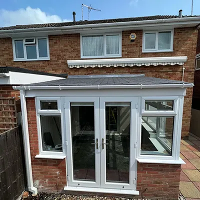 A brick house with a white door and windows.
